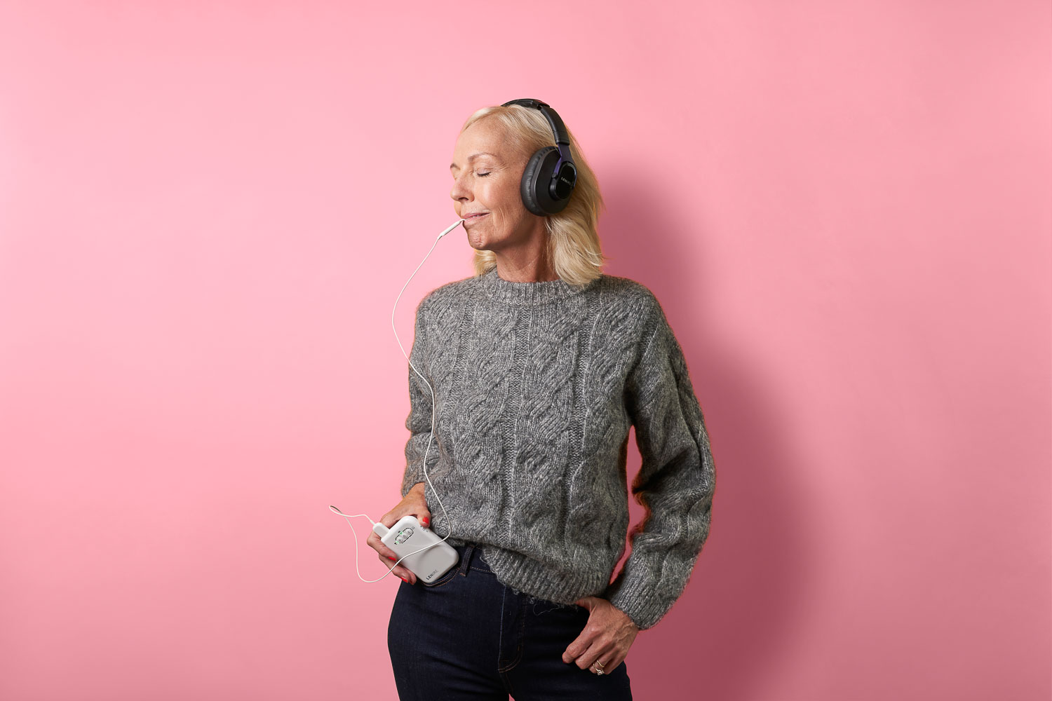 Patient using the Lenire bimodal neuromodulation device at home, wearing headphones and holding the controller