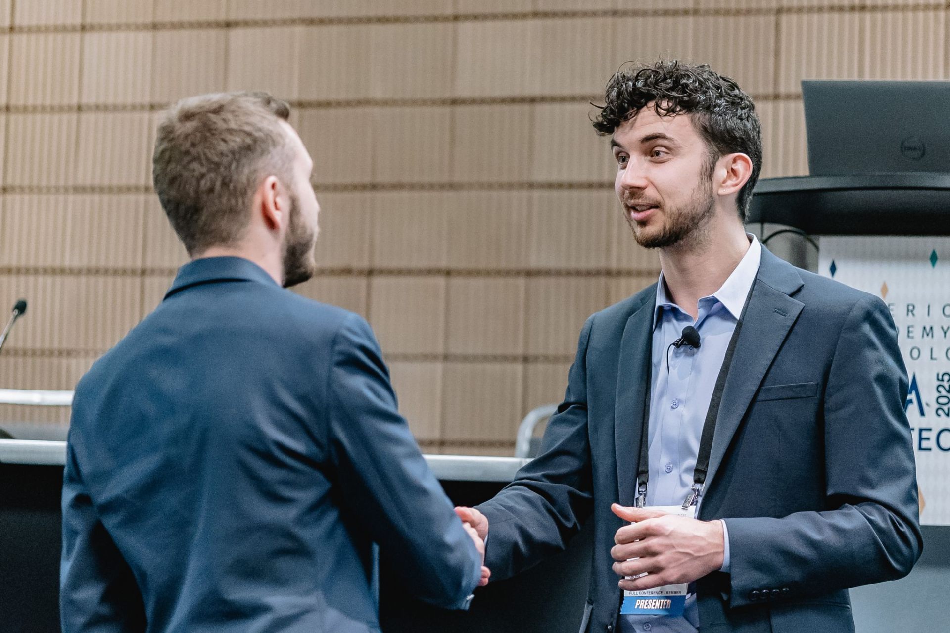 Ben shaking hands with a colleague at a conference