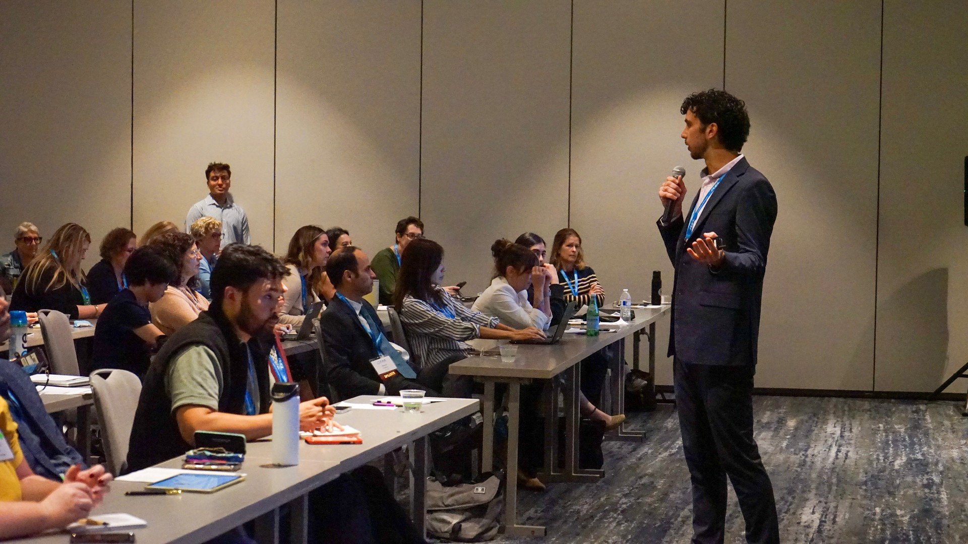 Ben speaking with a microphone in front of a conference audience